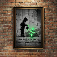A monochromatic Banksy-style street art print of a hooded child watering a glowing neon green plant growing from a cracked wall with stenciled text reading HOPE GROWS IN THE CRACKS, created by Artazyn.