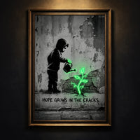 A monochromatic Banksy-style street art print of a hooded child watering a glowing neon green plant growing from a cracked wall with stenciled text reading HOPE GROWS IN THE CRACKS, created by Artazyn.