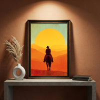 Retro vintage style illustration of a silhouette of a cowboy on horseback riding toward a massive bright orange and yellow setting sun over layered mountain ridges, created by Artazyn.