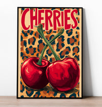 Retro pop art print featuring two large red cherries with green stems crossing against a leopard print background, with the word "CHERRIES" in bold red text.