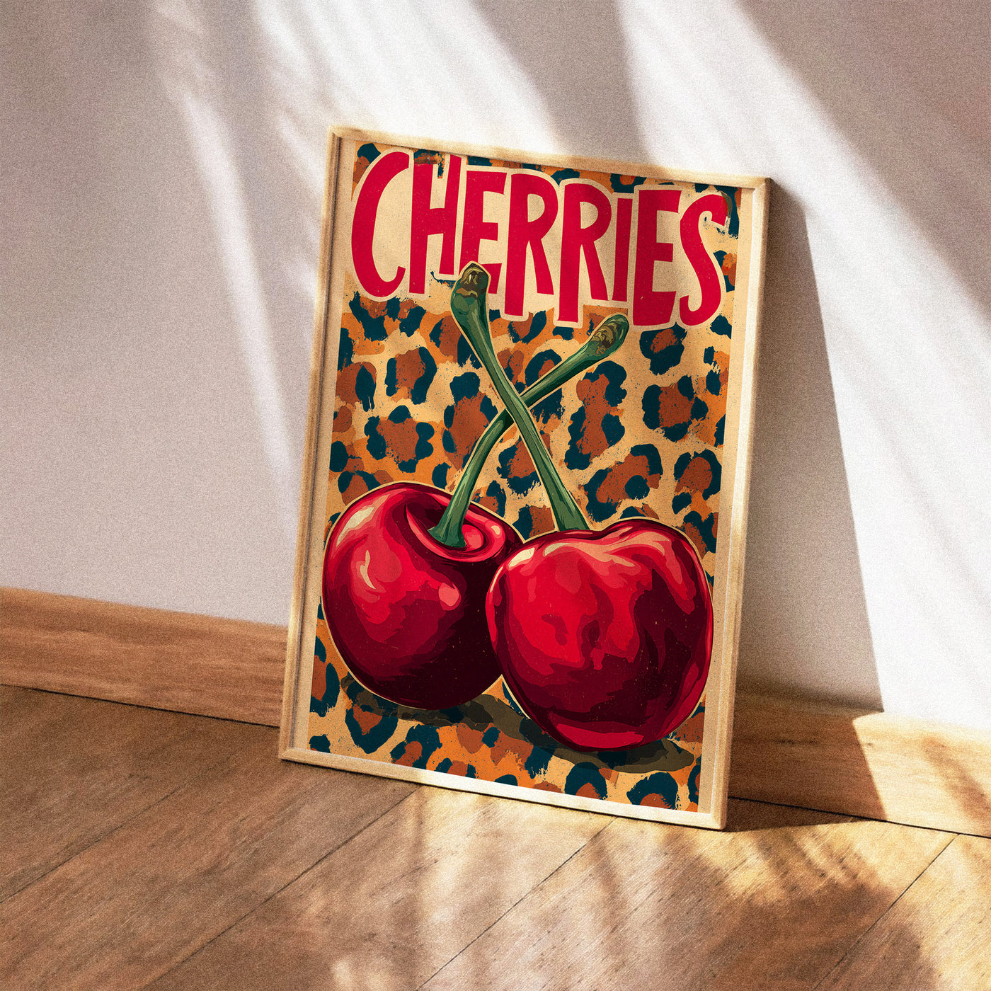 Retro pop art print featuring two large red cherries with green stems crossing against a leopard print background, with the word "CHERRIES" in bold red text.