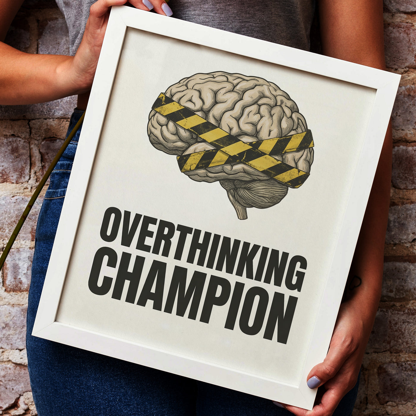 Framed poster with brain illustration and 'Overthinking Champion' text on a rustic wall.