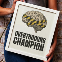 Framed poster with brain illustration and 'Overthinking Champion' text on a rustic wall.